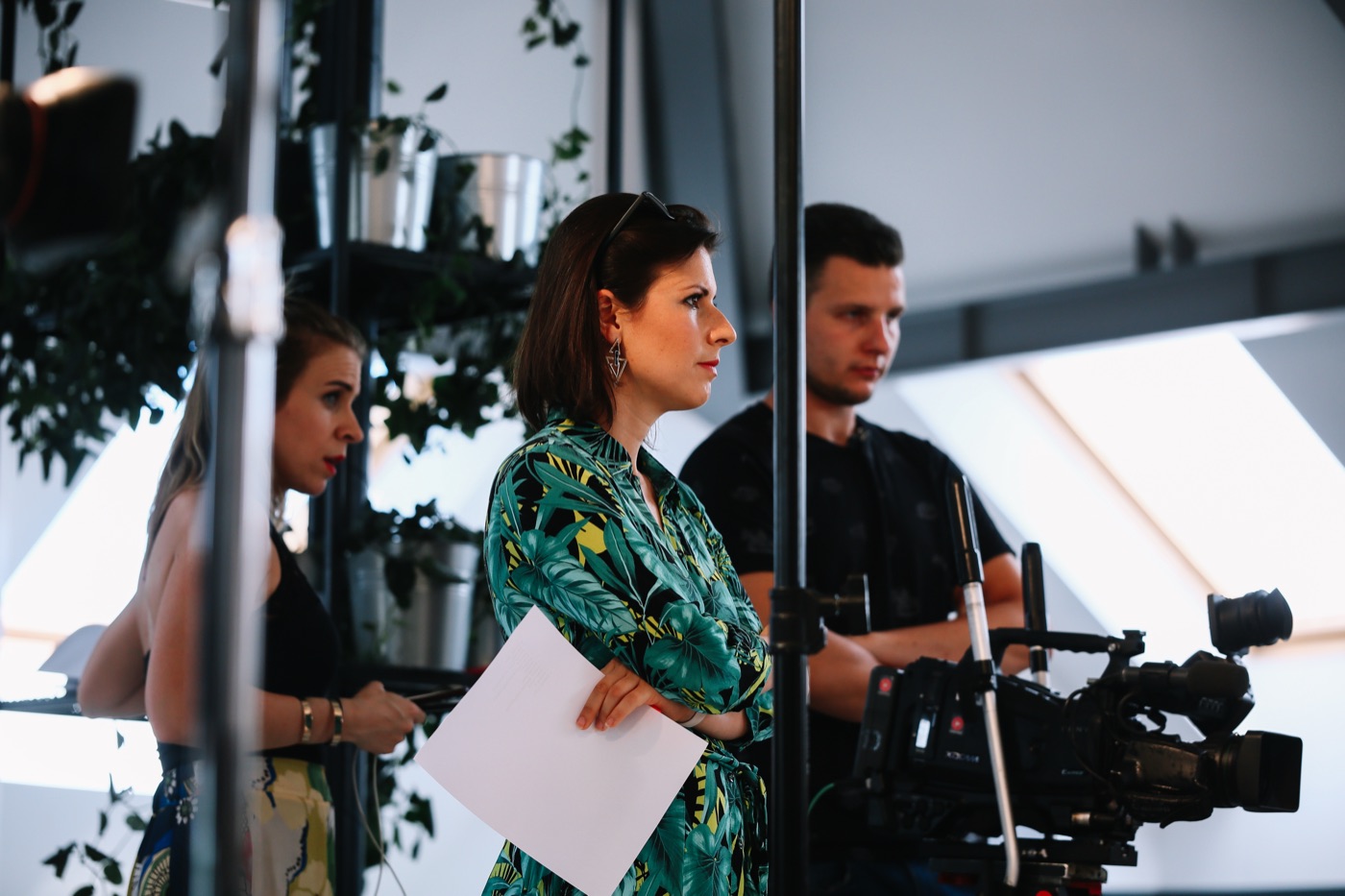 Irma on set, notes in hand, directing a production alongside a camera operator